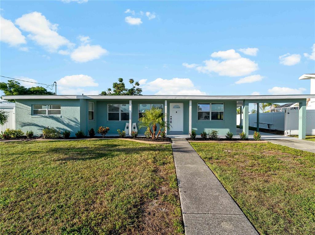 A single-story light green house with a flat roof and a concrete walkway — 581 LINDLEY TERRACE, PORT CHARLOTTE, FL