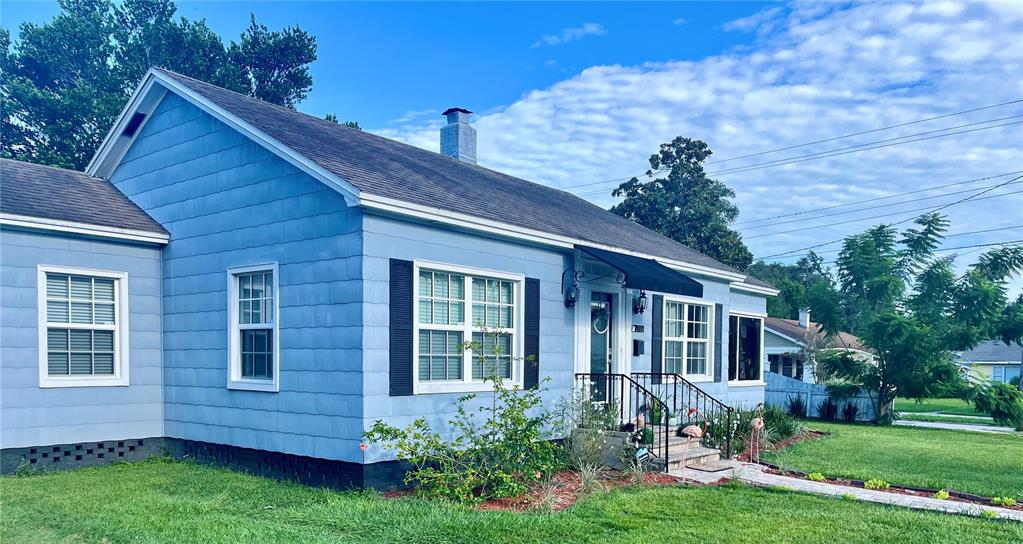 A blue, single-story house with a shingled roof, white-trimmed windows, and a front porch — 701 PARK HILL AVE, LAKELAND, FL