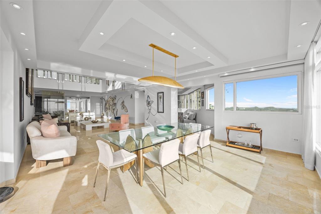 A bright dining and living area features a glass table, modern chairs, and marble flooring — 14 RD 833, LA CIMA UNIT PH 1901, GUAYNABO, PR