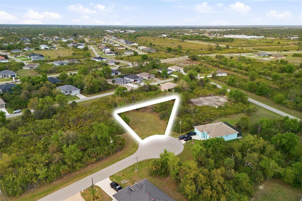 An aerial view shows a vacant, trapezoidal residential lot located at the end of a cul-de-sac — 118 DELWAY WAY, ROTONDA WEST, FL