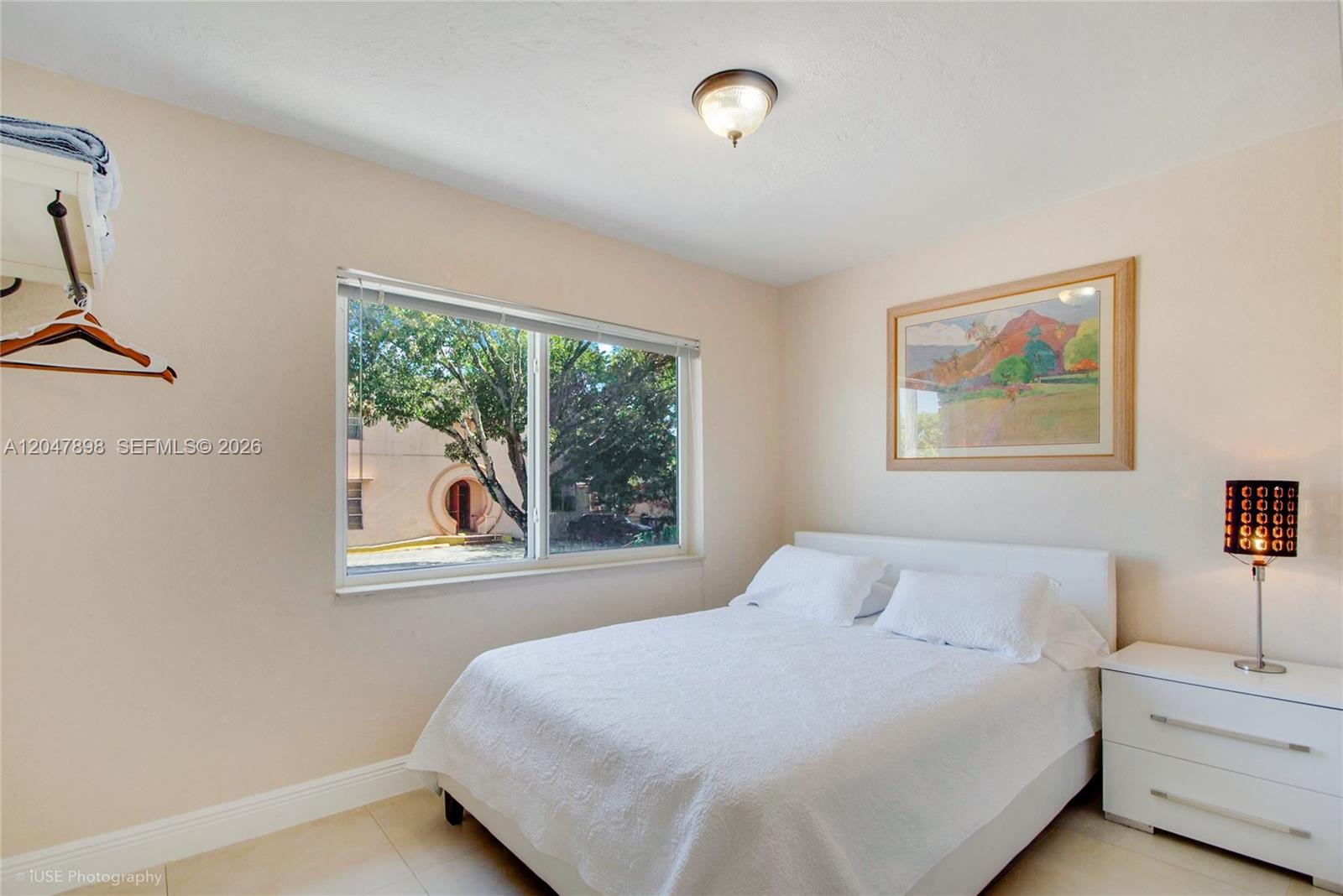 A bedroom features a white bed, a nightstand with a lamp, and a window view — 518 SW 7th Ave # 520, Miami FL 33130, MIAMI, FL