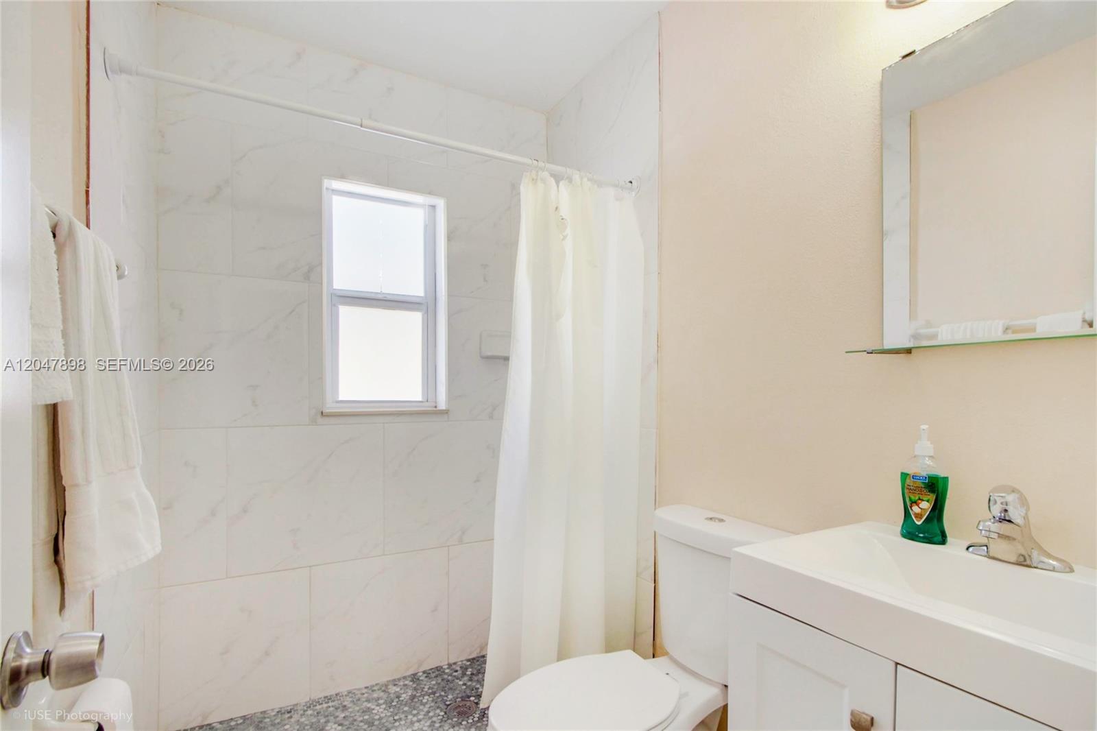 A bathroom features a tiled shower area, a white toilet, and a vanity with a mirror — 518 SW 7th Ave # 520, Miami FL 33130, MIAMI, FL