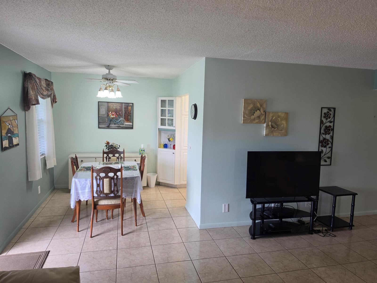 A dining area with a table and chairs sits adjacent to a living room space — 15 Markham # A, Deerfield Beach FL 33442, DEERFIELD BEACH, FL