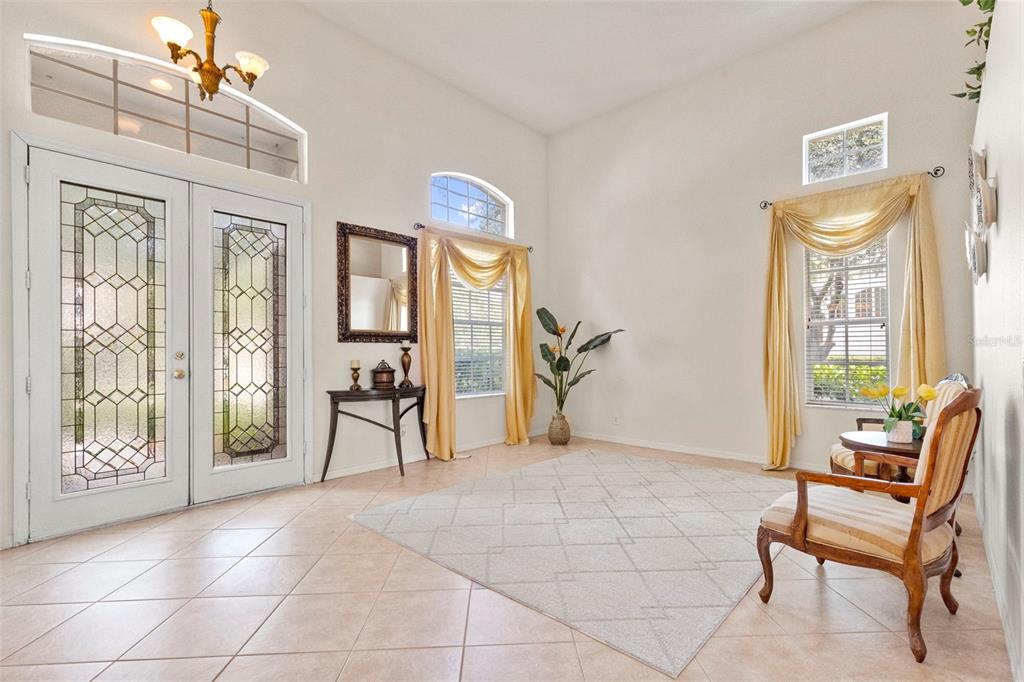 A bright foyer with tile floors, high ceilings, arched windows, and a double glass door — 17823 ARBOR CREEK DRIVE, TAMPA, FL