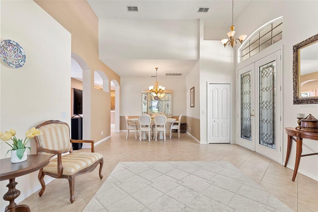 A bright foyer with tile floors leads to a dining area with a high ceiling — 17823 ARBOR CREEK DRIVE, TAMPA, FL