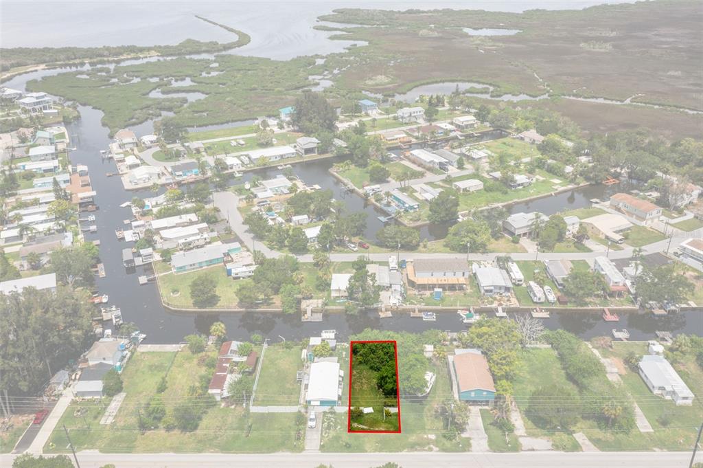 An aerial view shows a vacant, rectangular lot outlined in red along a canal — 0 OLD DIXIE HIGHWAY, HUDSON, FL