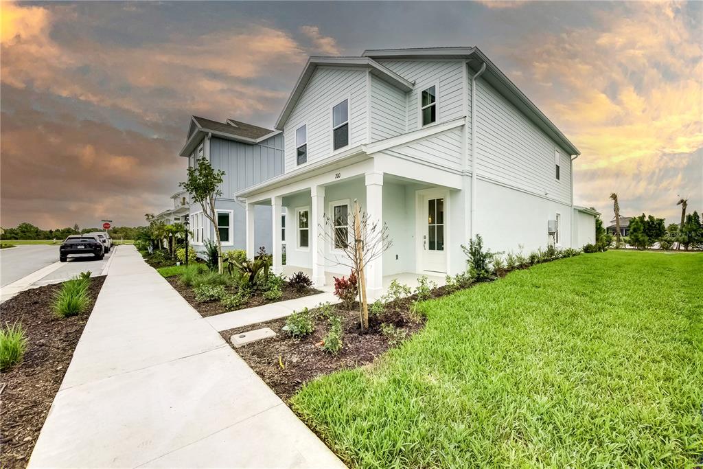 A two-story light blue house with a front porch and a green lawn — 200 EAGLESTON LANE, LAKEWOOD RANCH, FL