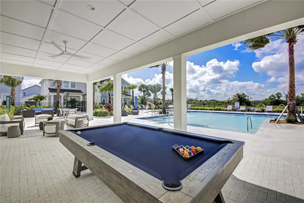 A covered outdoor patio features a pool table, lounge seating, and a swimming pool — 200 EAGLESTON LANE, LAKEWOOD RANCH, FL
