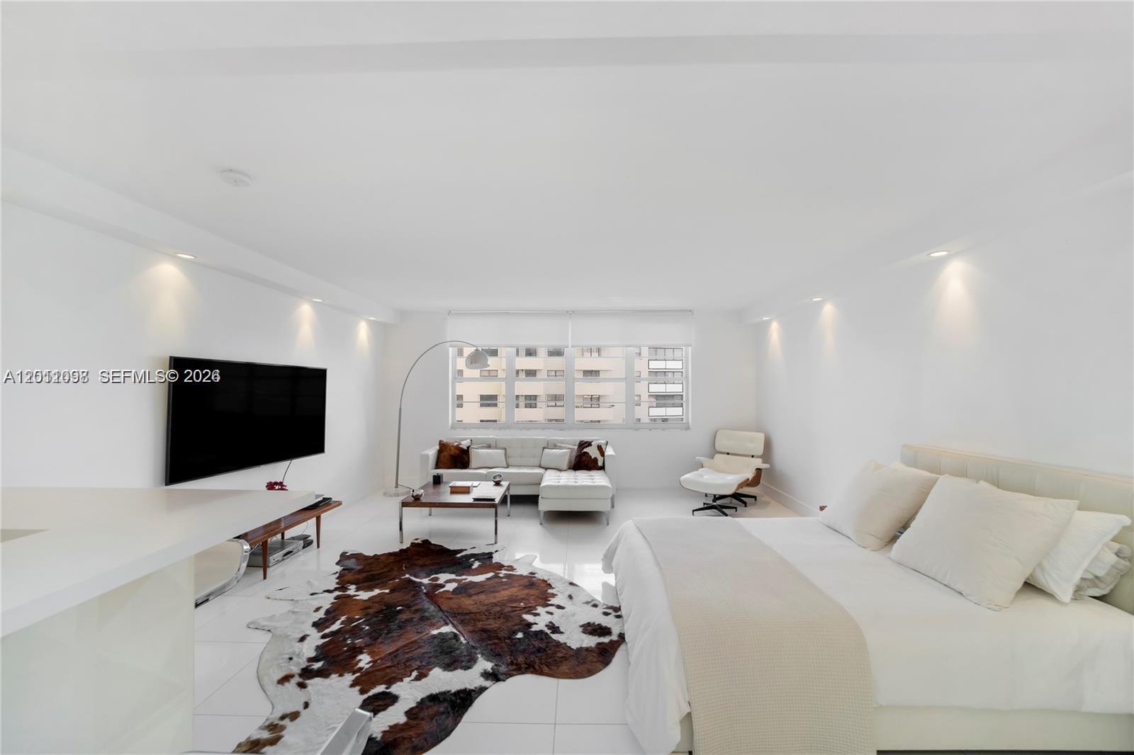 A bright, open-concept studio apartment features white tile floors, a bed, and a living area — 100 Lincoln Rd # 605, Miami Beach FL 33139, MIAMI BEACH, FL