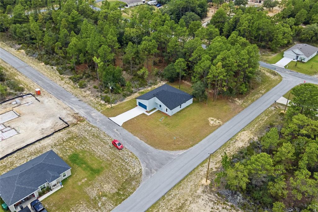 An aerial view shows a single-story house with a dark roof on a corner lot — 10708 N CALDERA AVENUE, CITRUS SPRINGS, FL