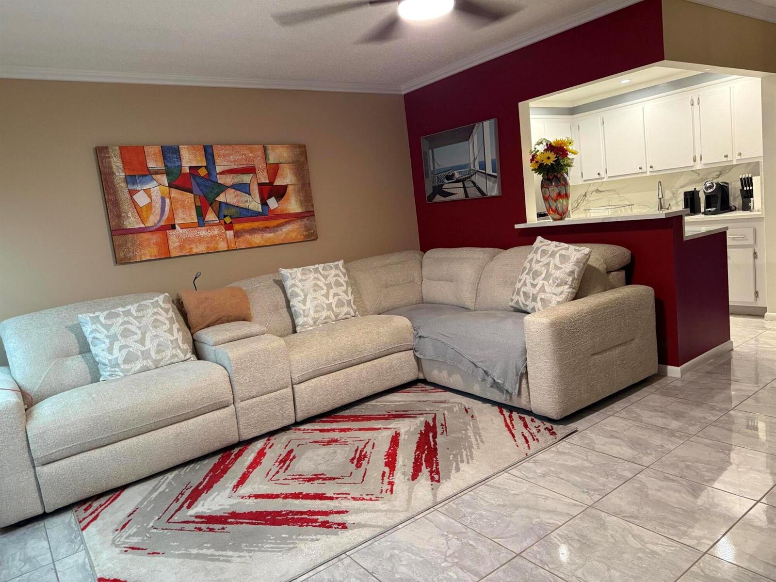 A living room features a large sectional sofa, a patterned rug, and a red accent wall — 362 Oakridge T, Deerfield Beach FL 33442, DEERFIELD BEACH, FL