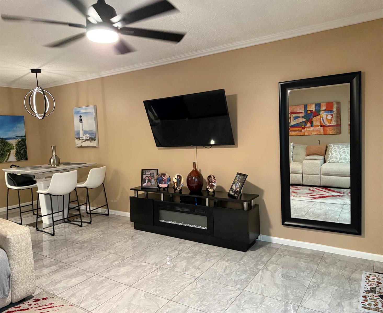 A living and dining area features tile floors, a wall-mounted television, and a large mirror — 362 Oakridge T, Deerfield Beach FL 33442, DEERFIELD BEACH, FL