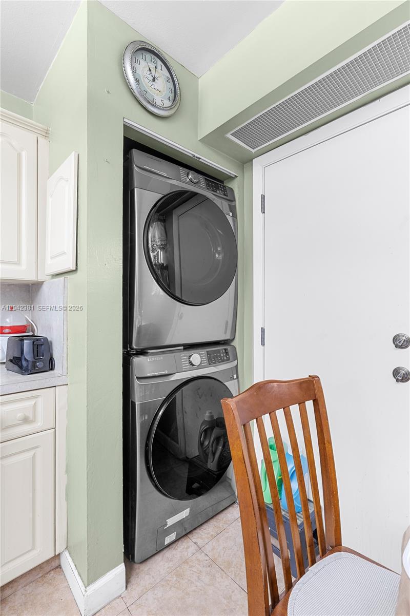 A stacked Samsung washer and dryer unit is installed in a kitchen alcove — 1800 W 54th St # 209, Hialeah FL 33012, HIALEAH, FL