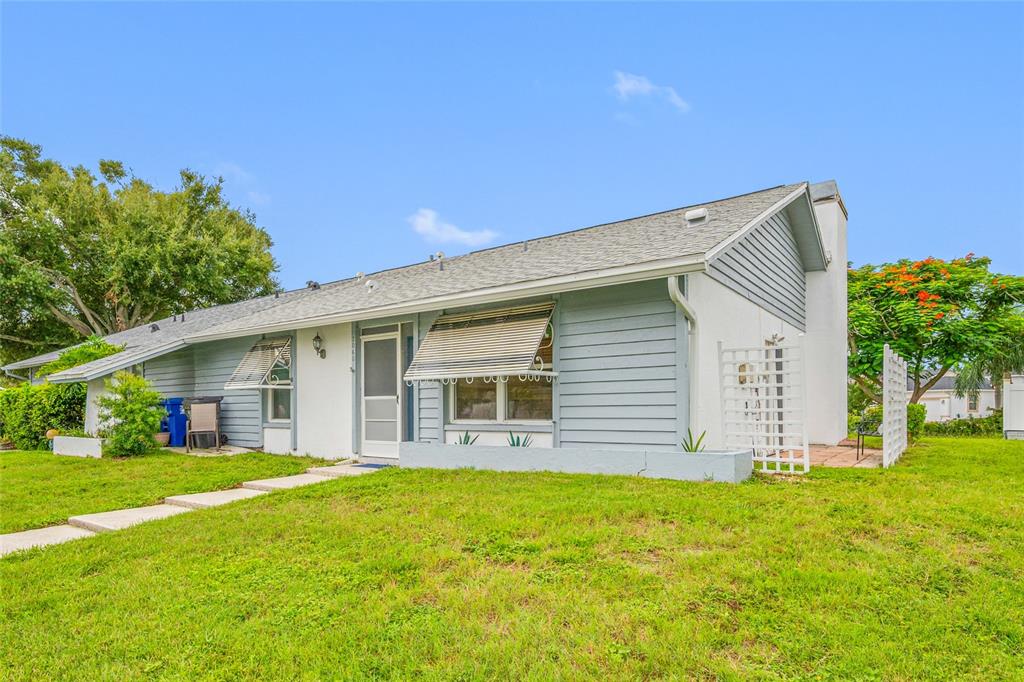 A single-story house with light blue horizontal siding, a gray roof, and a front lawn — 2060 SHEFFIELD COURT, OLDSMAR, FL