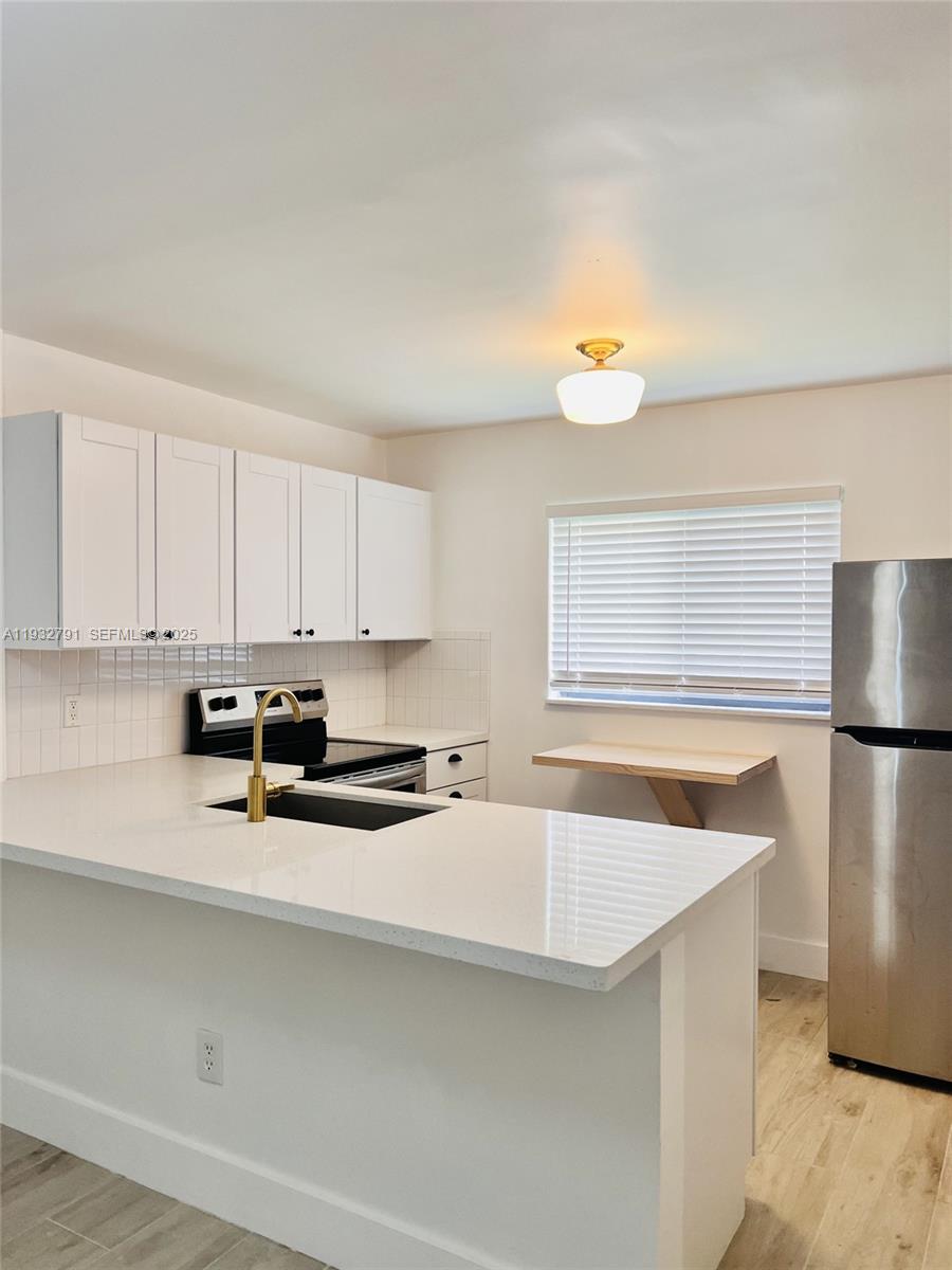 An empty room features cream-colored walls, a window with blinds, and speckled terrazzo flooring — 910 SW 4th Ave # 3, Miami FL 33130, MIAMI, FL