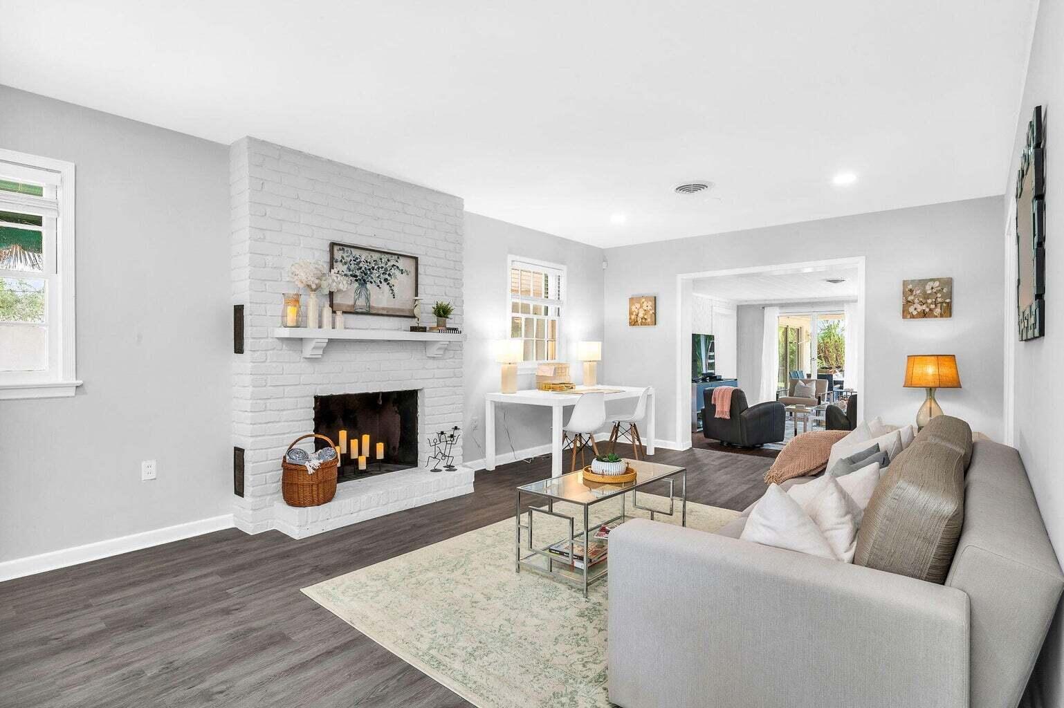 A living room features a white brick fireplace, gray flooring, and a neutral sofa — 127 Miramar Way, West Palm Beach FL 33405, WEST PALM BEACH, FL