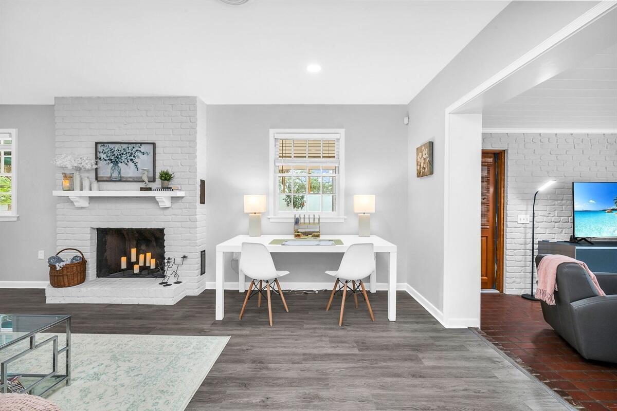 A living room features a white brick fireplace, a desk with two chairs, and gray flooring — 127 Miramar Way, West Palm Beach FL 33405, WEST PALM BEACH, FL