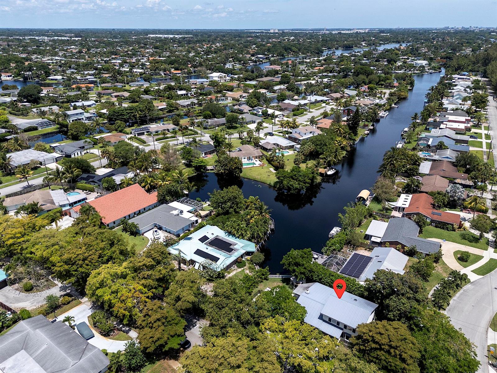 Aerial view of a waterfront residential neighborhood featuring a house marked with a red pin — 1808 N 17th Ave Avenue N, FL 33460, FL