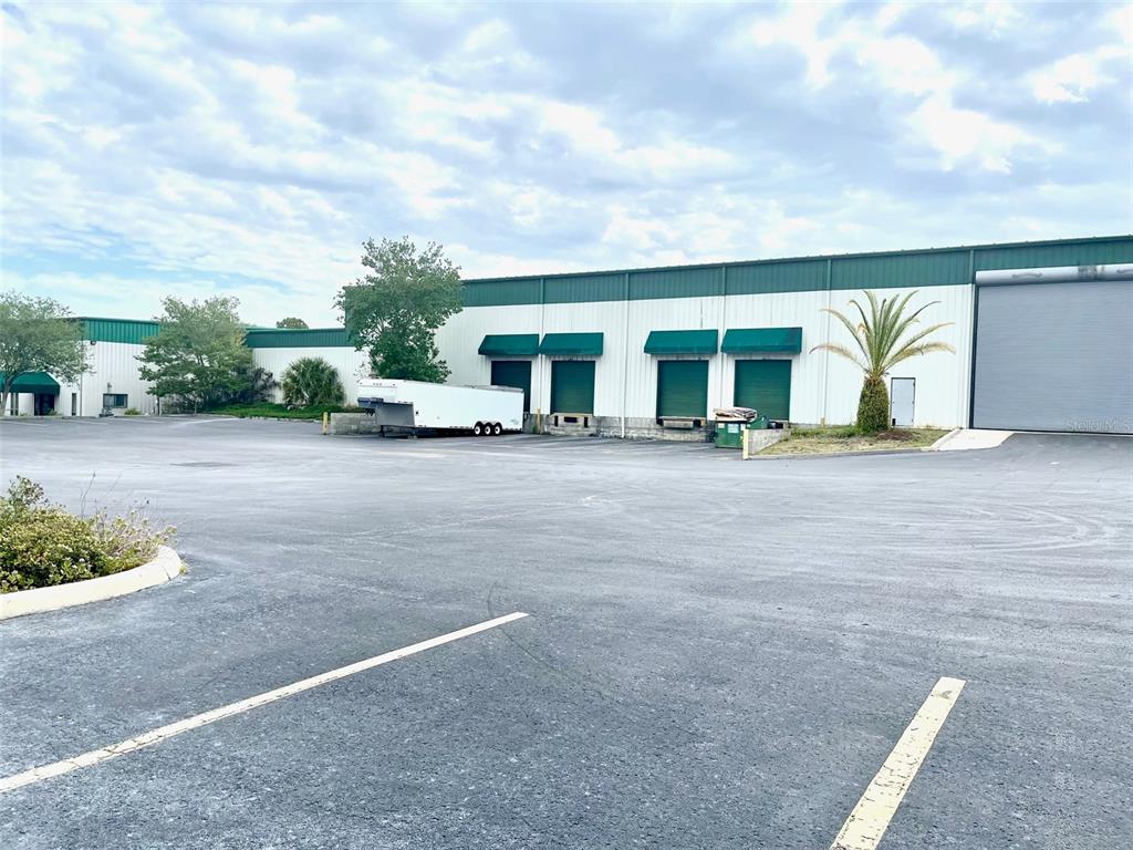 A large industrial warehouse building features multiple loading docks and a paved parking lot — 19994 INDEPENDENCE BOULEVARD, GROVELAND, FL