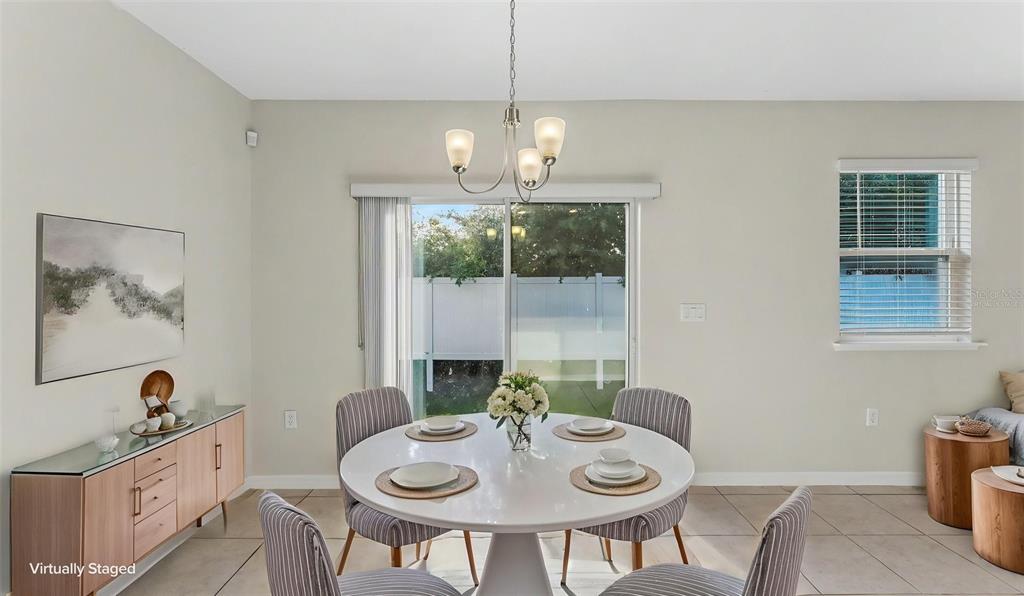 A dining area with a round white table, four chairs, and a sliding glass door — 4925 JACKSON STREET, WINTER HAVEN, FL