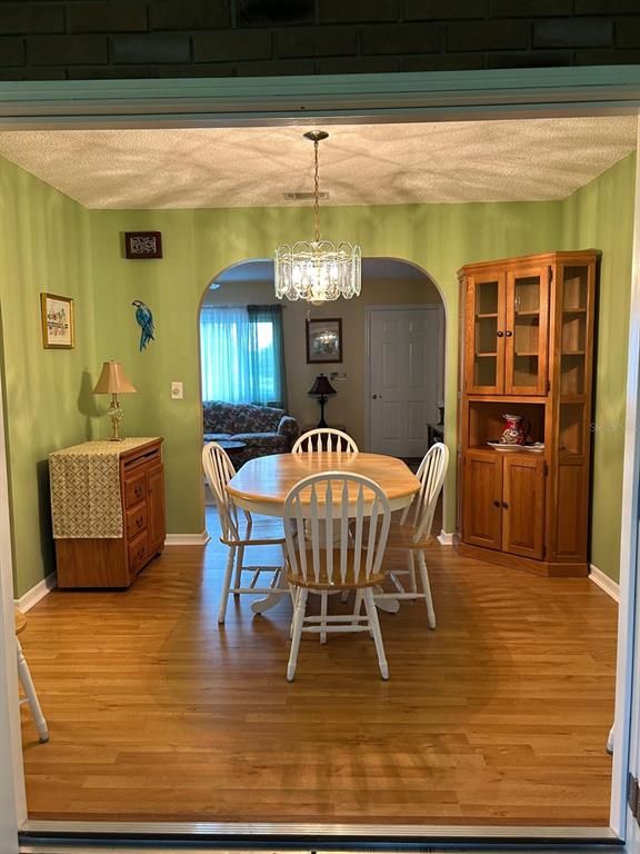 A dining room with green walls, a wooden table, four chairs, and a corner hutch — 10397 SE 176TH STREET, SUMMERFIELD, FL