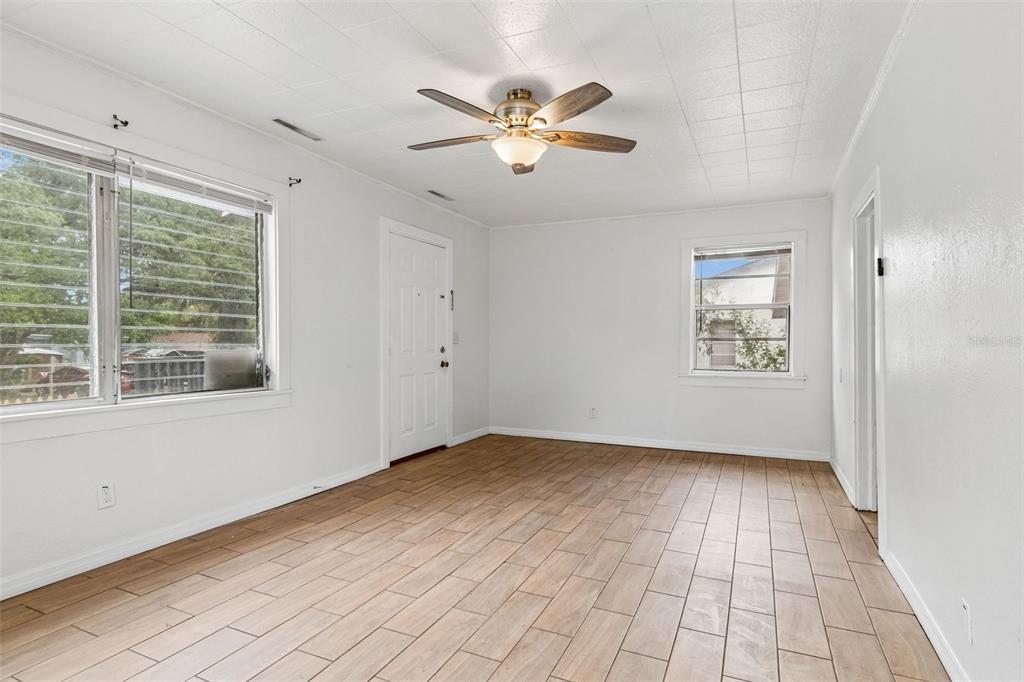 An empty room with white walls, wood-look tile flooring, a ceiling fan, and two windows — 1363 TIOGA AVENUE, CLEARWATER, FL