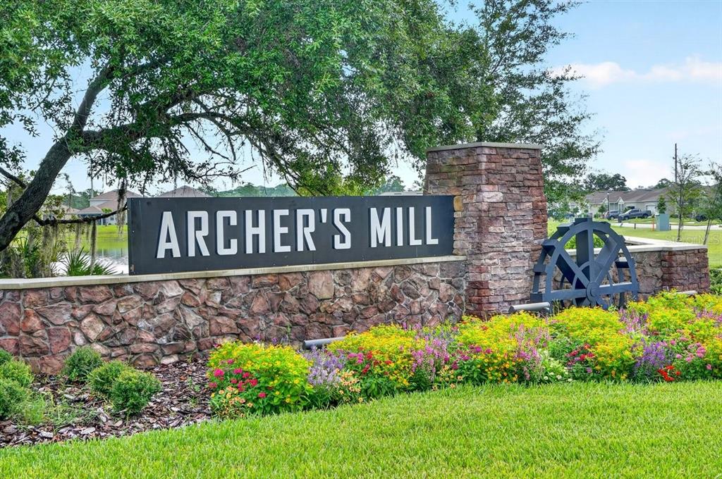 A stone monument sign for Archer's Mill stands in front of a garden and pond — 349 ROVER ROAD, ORMOND BEACH, FL