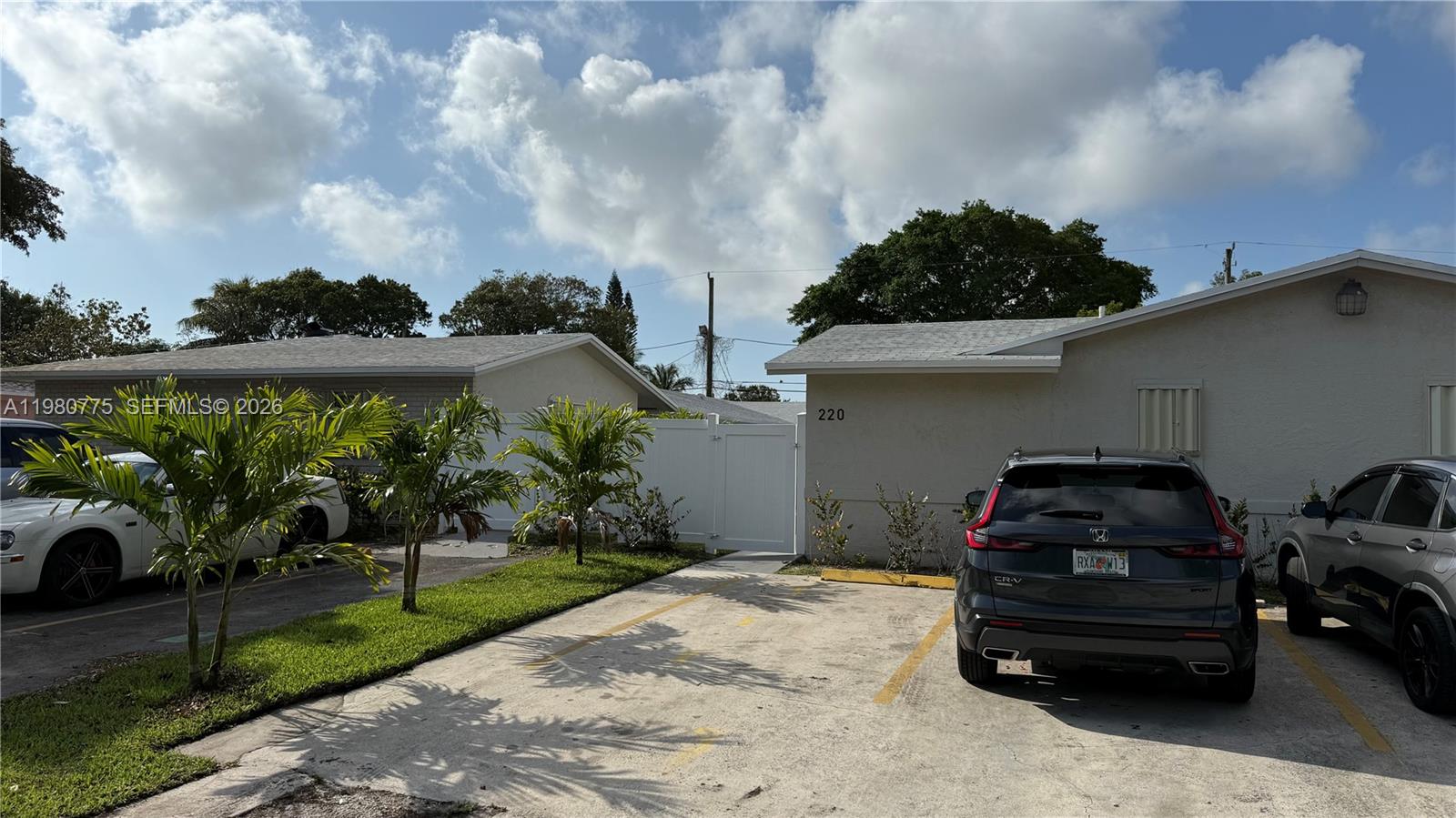 A paved parking area sits in front of two single-story buildings with a white fence — 220 NW 12th St, Pompano Beach FL 33060, POMPANO BEACH, FL