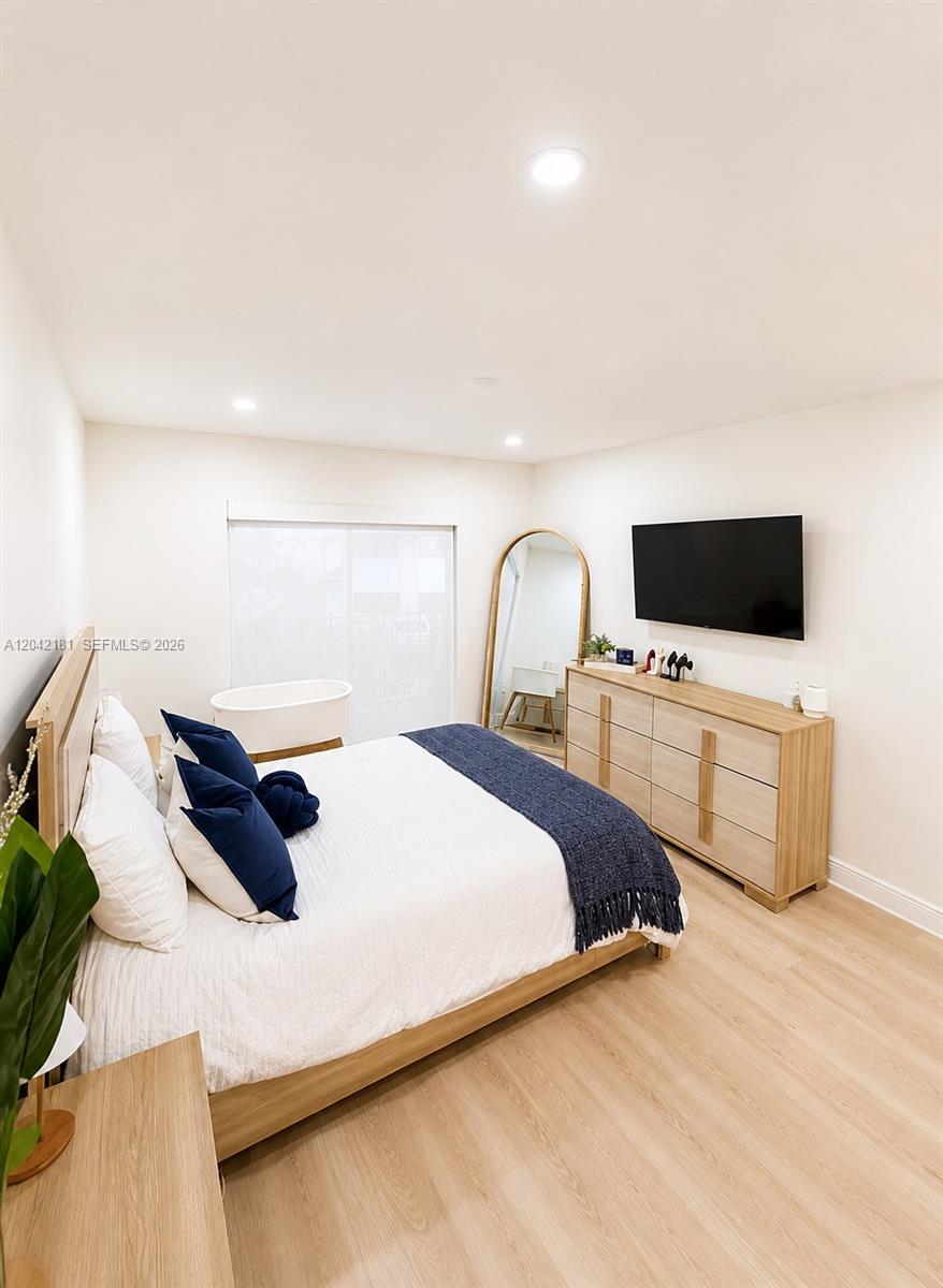 A bedroom features a bed with blue accents, a wooden dresser, and a floor mirror — 13251 SW 17th Ln # 5, Miami FL 33175, MIAMI, FL