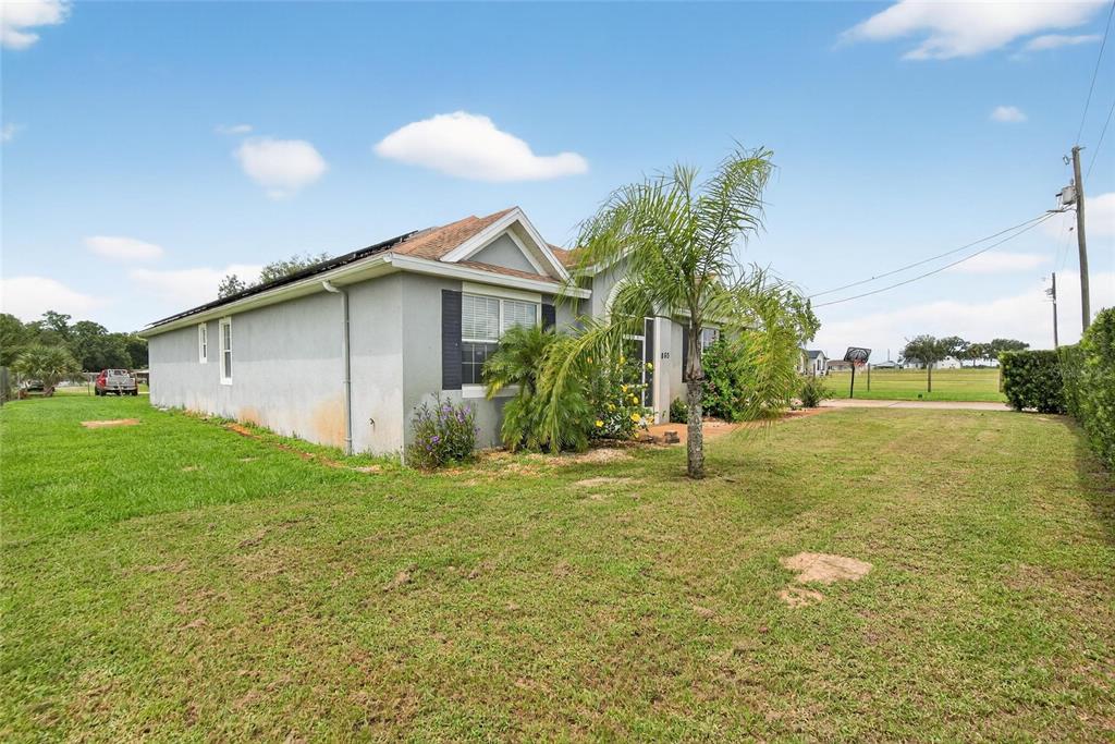 A single-story house with a gray exterior, a palm tree, and a large grassy yard — 863 C F KINNEY ROAD, LAKE WALES, FL
