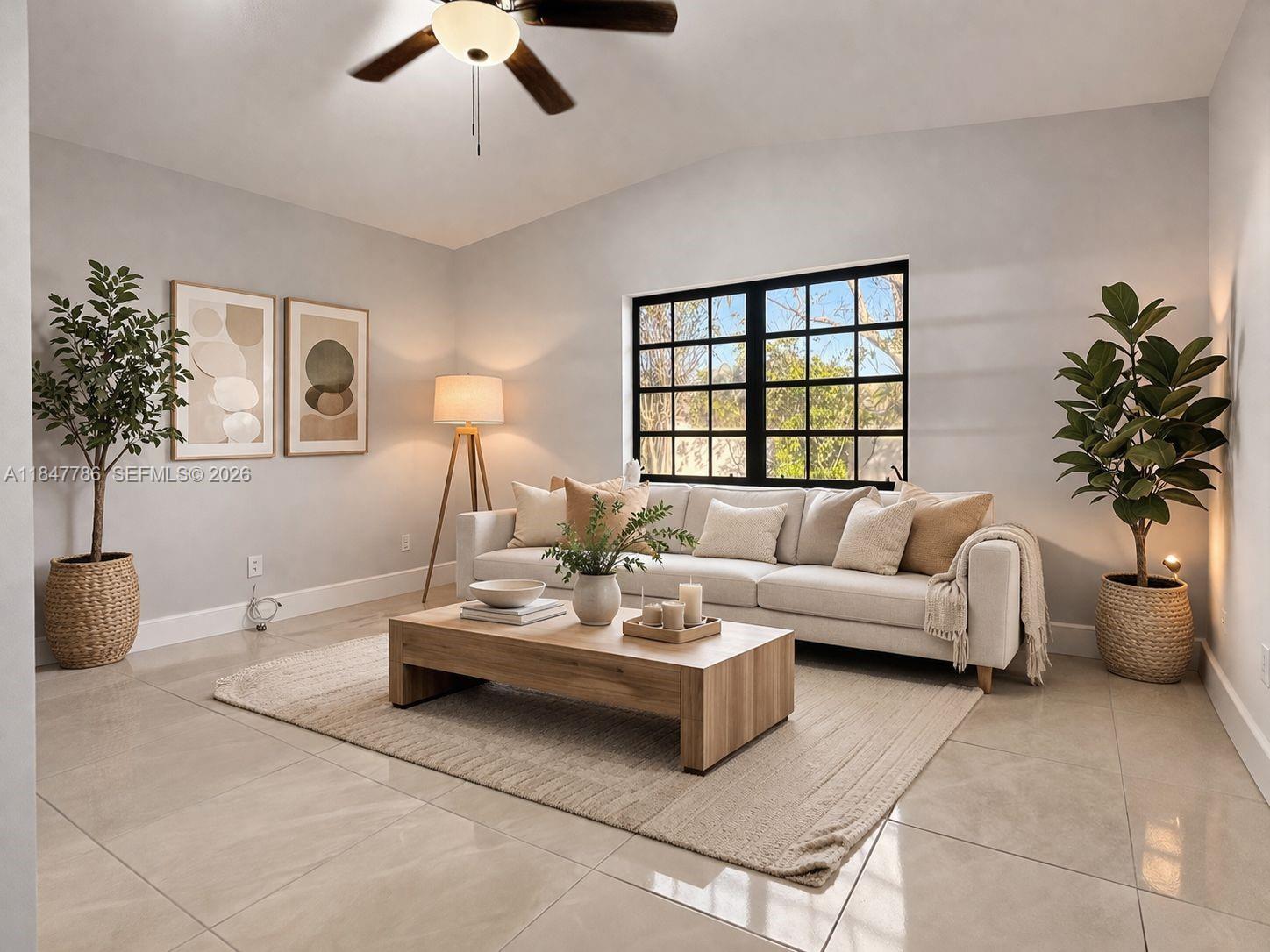 A living room features a beige sofa, a wooden coffee table, and two potted plants — 13925 SW 26th Ter, Miami FL 33175, MIAMI, FL