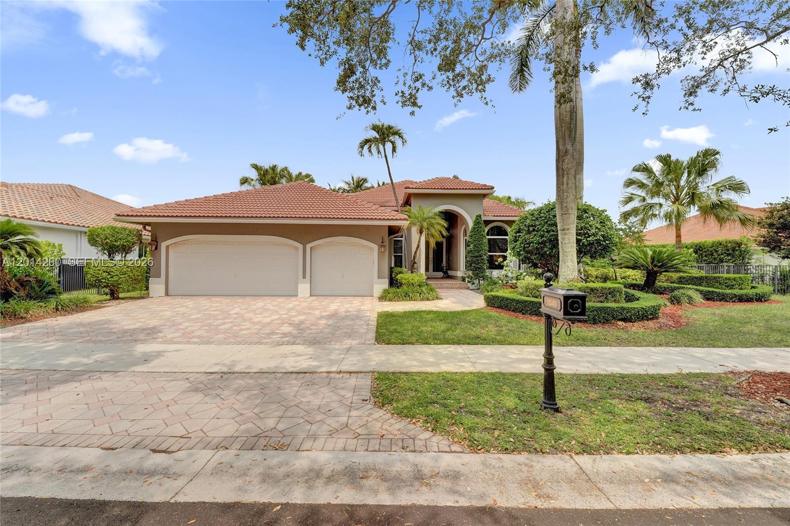 A single-story house with a tiled roof, two-car garage, and landscaped front yard — 1640 Island Way, Weston FL 33326, WESTON, FL