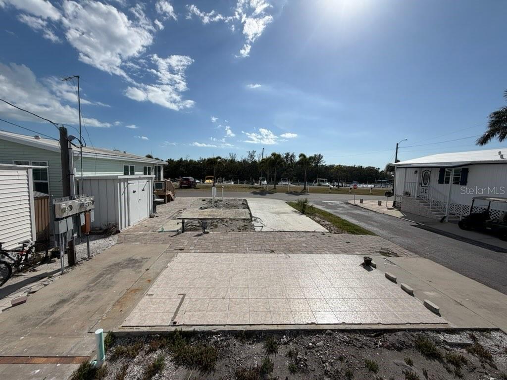 An outdoor lot features a paved patio area with a tiled section and adjacent concrete pads — 10315 CORTEZ ROAD W UNIT 4-4, BRADENTON, FL