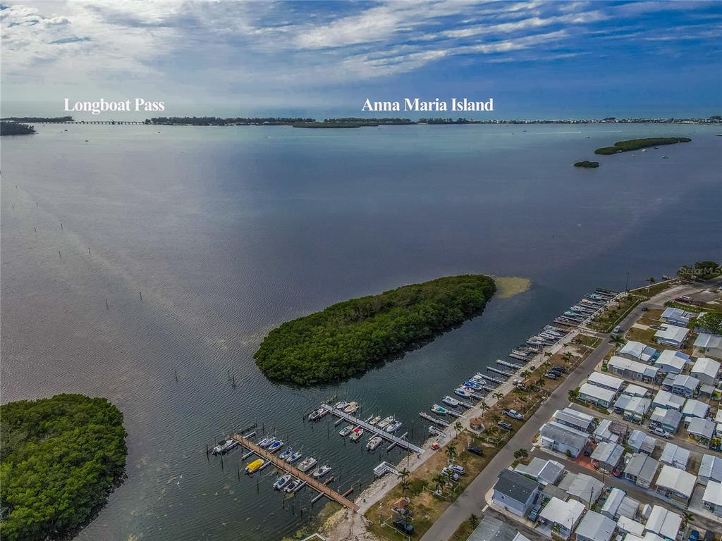 An aerial view shows a marina, a mangrove island, and a residential community near water — 10315 CORTEZ ROAD W UNIT 4-4, BRADENTON, FL