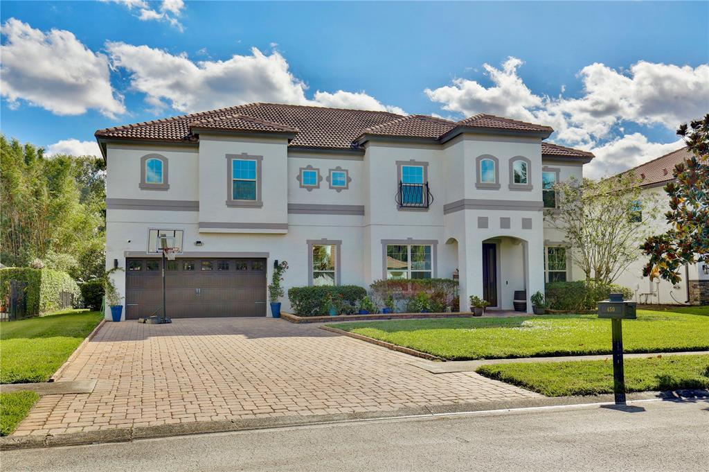 A two-story stucco house features a brown tile roof, a three-car garage, and a driveway — 450 TERRAVISTA PLACE, OVIEDO, FL