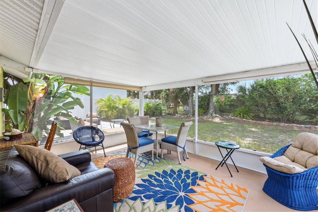 A screened-in patio features a dining set, lounge furniture, and a view of the backyard — 4166 POMPANO ROAD, VENICE, FL