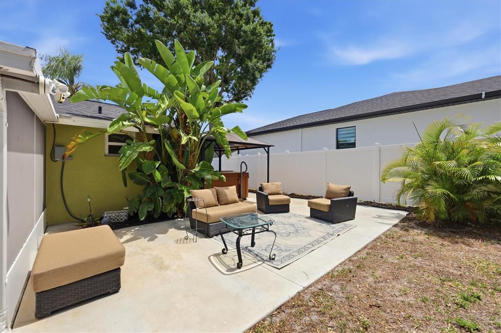A concrete patio features outdoor furniture, a hot tub, and large tropical plants — 4166 POMPANO ROAD, VENICE, FL