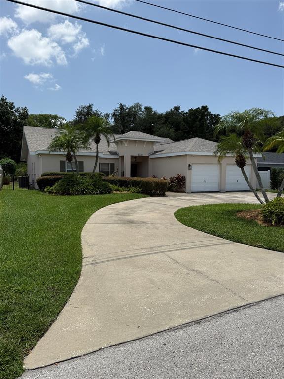 A single-story house with a two-car garage and a concrete driveway at sunset — 2708 W OSBORNE AVENUE, TAMPA, FL