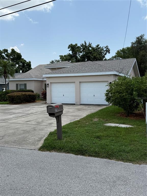 A concrete walkway leads to the front entrance of a house with beige stucco walls — 2708 W OSBORNE AVENUE, TAMPA, FL