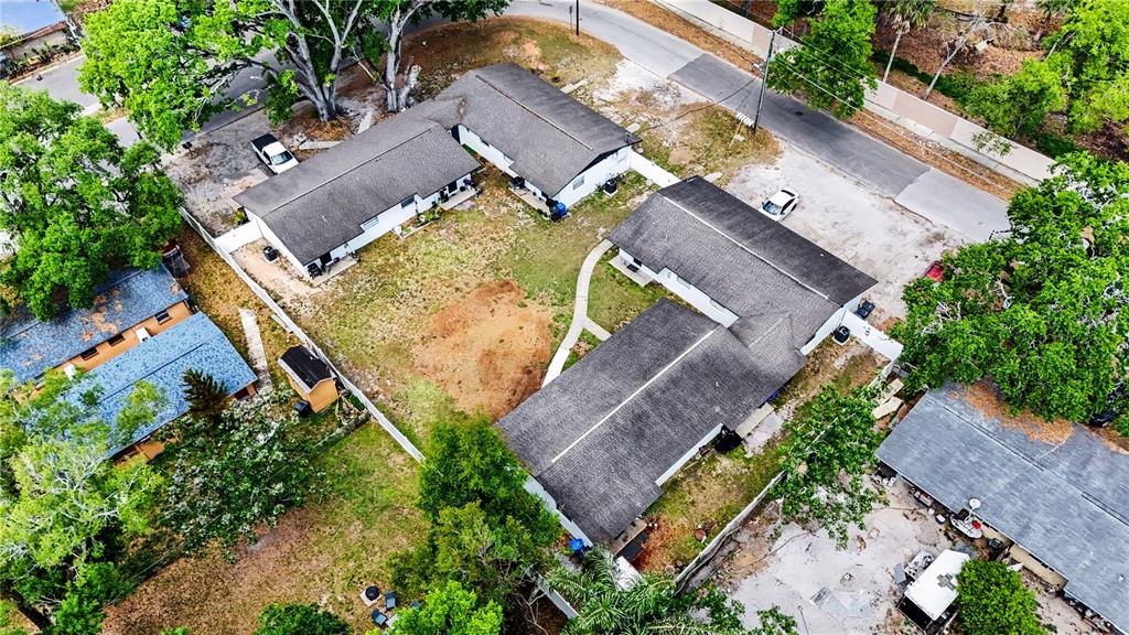 An aerial view shows two L-shaped residential buildings with gray roofs on a grassy lot — 14207 N 12TH STREET UNIT A, TAMPA, FL