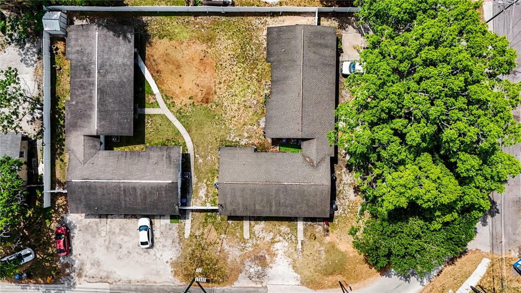 An aerial view shows two L-shaped apartment buildings with parking spaces and a large tree — 14207 N 12TH STREET UNIT A, TAMPA, FL