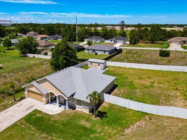 An aerial view shows a single-story house with a fenced backyard and surrounding neighborhood — 13338 SW 48TH AVENUE, OCALA, FL
