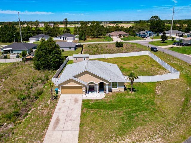 An aerial view shows a single-story house with a fenced yard and a concrete driveway — 13338 SW 48TH AVENUE, OCALA, FL