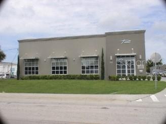 A single-story commercial building with a gray facade, large windows, and a grassy front lawn — 145 RONNING WAY, LONGWOOD, FL