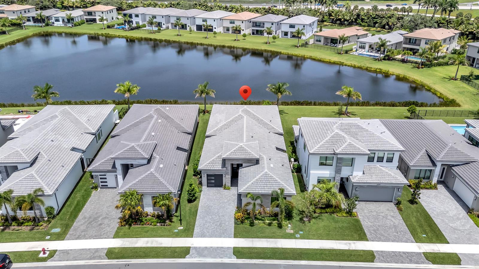 An aerial view shows a row of modern suburban houses facing a large lake — 20092 Hirono Lane, Boca Raton FL 33434, BOCA RATON, FL