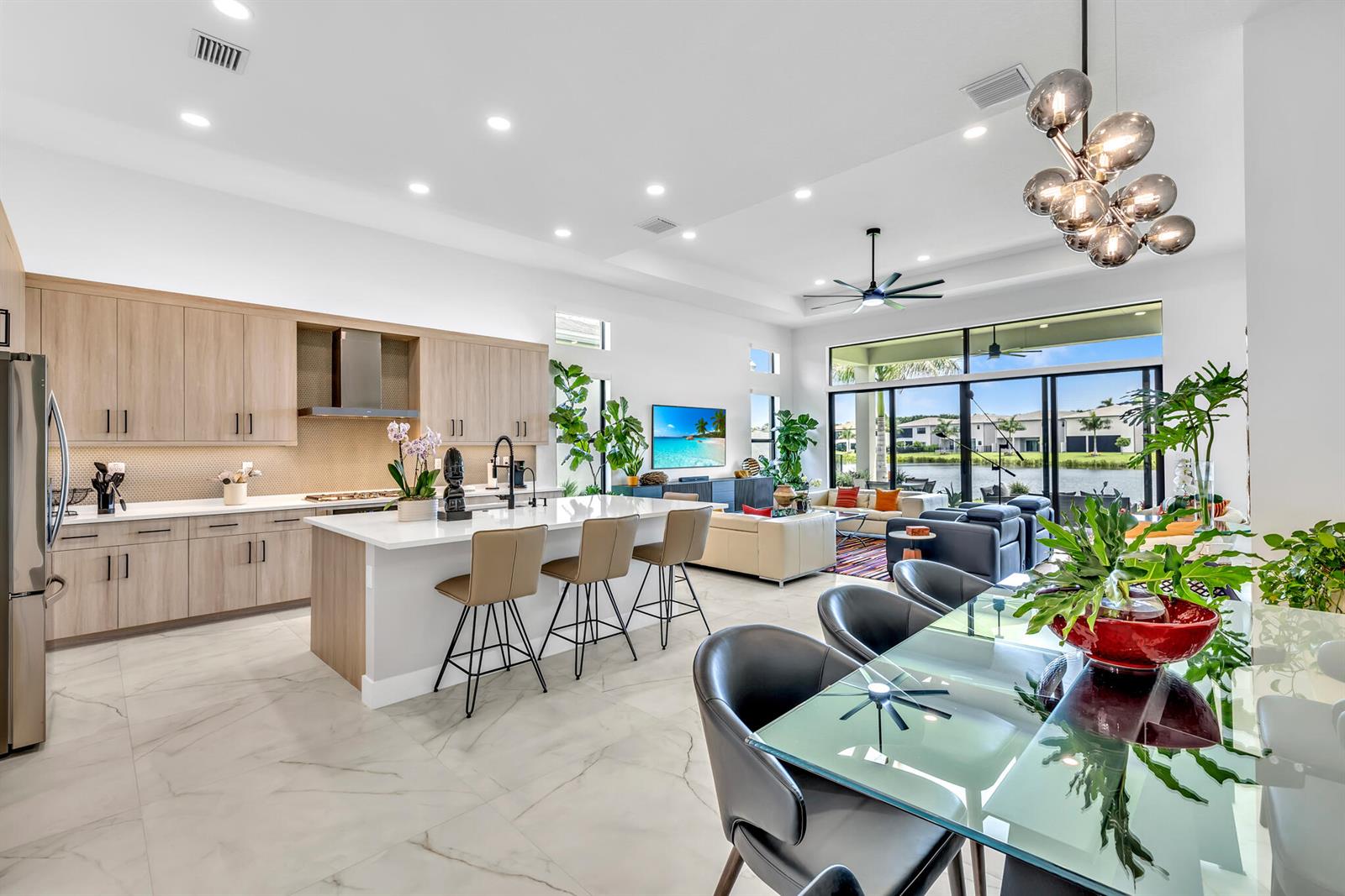 An open-concept kitchen and living area features light wood cabinetry, a large island, and lakefront views — 20092 Hirono Lane, Boca Raton FL 33434, BOCA RATON, FL