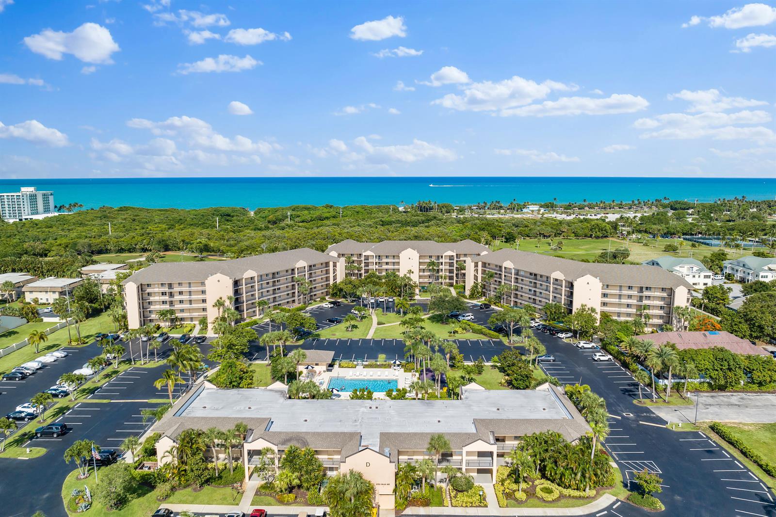 An aerial view shows a multi-building apartment complex with a central pool and parking lots — 275 Palm Avenue # A301, Jupiter FL 33477, JUPITER, FL