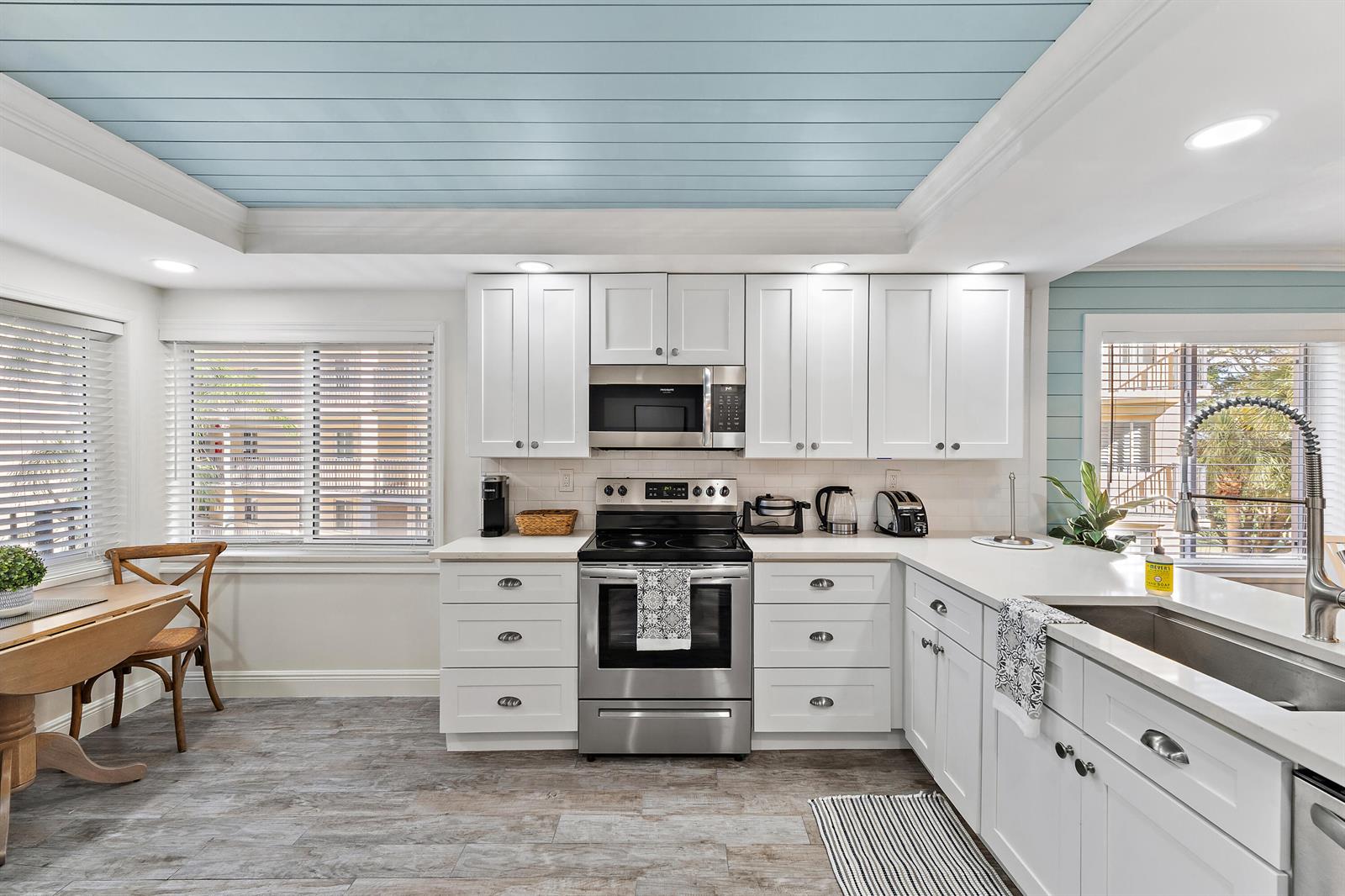 A kitchen with white cabinets, stainless steel appliances, and a light blue shiplap ceiling — 275 Palm Avenue # A301, Jupiter FL 33477, JUPITER, FL