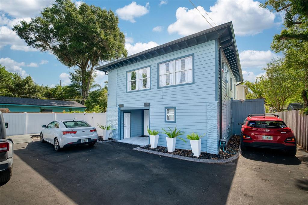 A two-story light blue house with a paved driveway and two parked cars — 1421, 1423, 1425, 1427 ASHER LANE, ORLANDO, FL