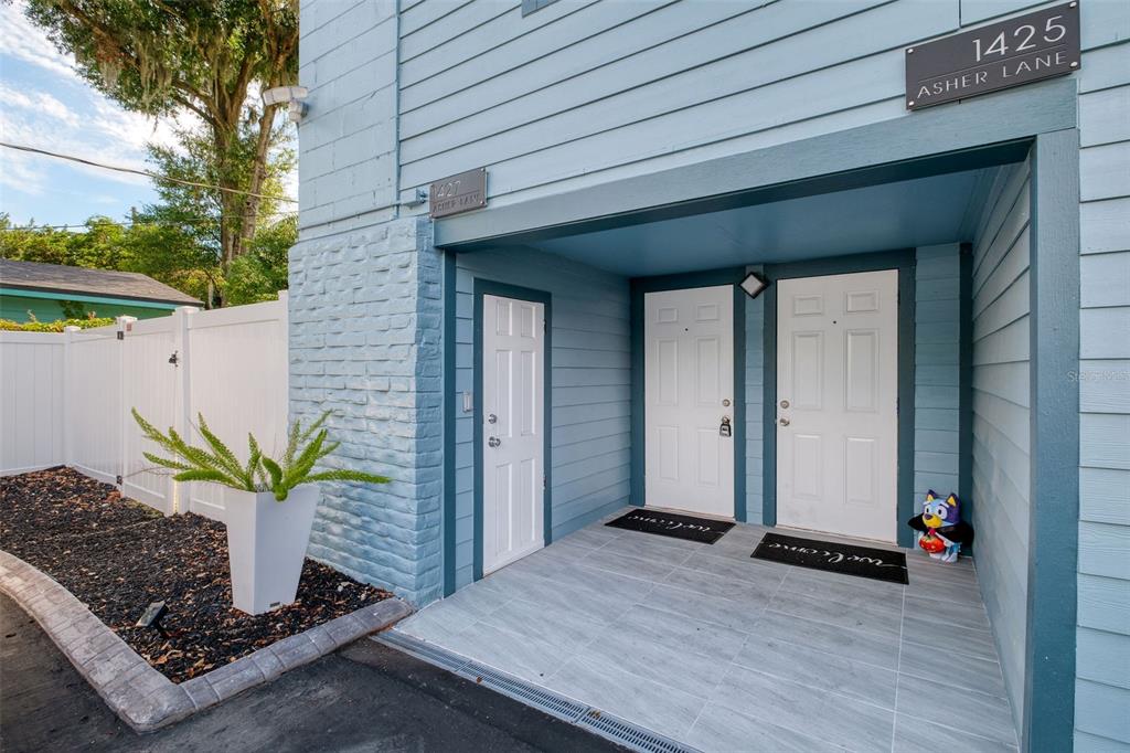 The exterior of a blue building features two white doors and a small storage door — 1421, 1423, 1425, 1427 ASHER LANE, ORLANDO, FL
